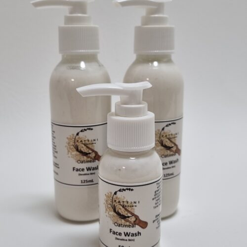 Three bottles of oatmeal face wash with white pump dispensers, featuring a label with an oatmeal graphic and product details.
