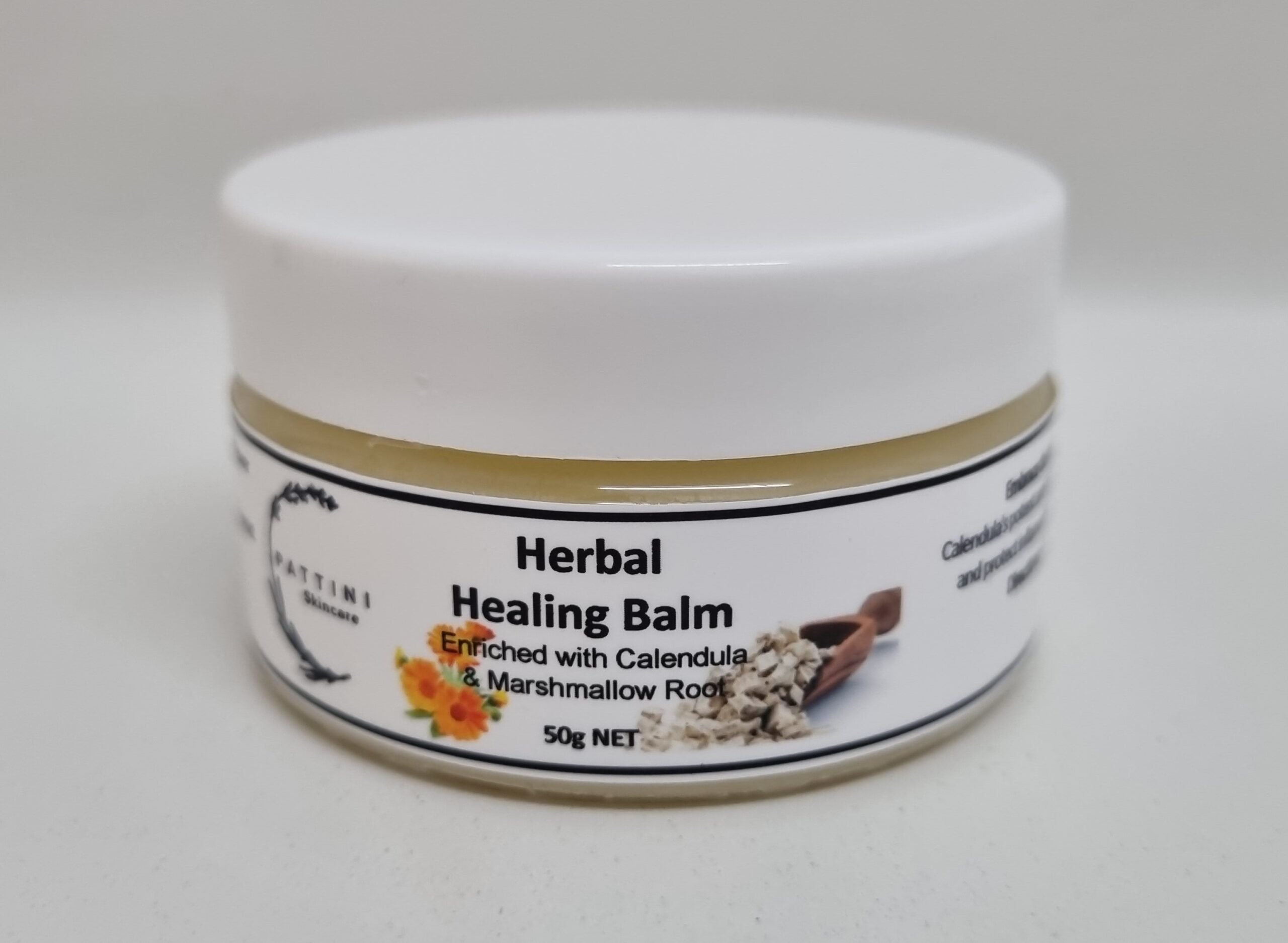 A small white jar of Pattini Skincare Herbal Healing Balm with a label featuring calendula flowers and marshmallow root.
