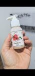 A hand holding a small pump bottle labeled Silky Rose Face Wash 50mL from Pattini Skincare.
