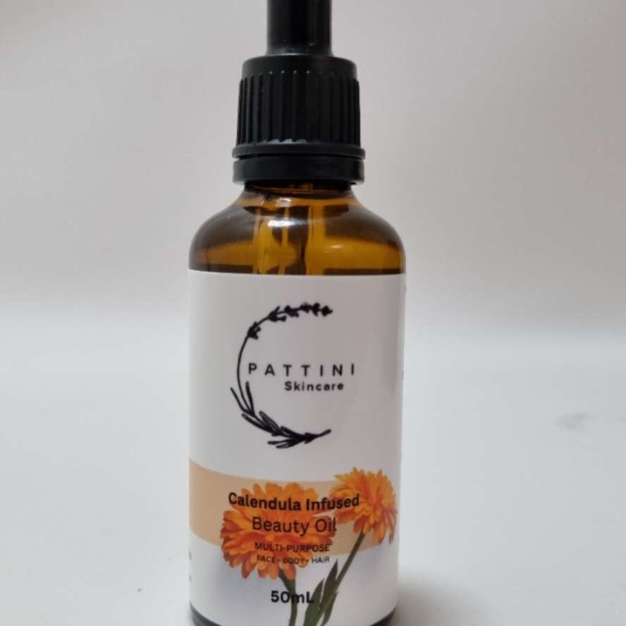 A small amber glass dropper bottle of Pattini Skincare Calendula Herbal Oil placed against a plain white background.